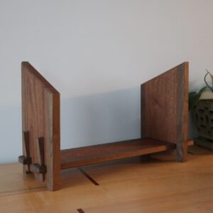 wooden bookshelf with angle bookends next to a plant