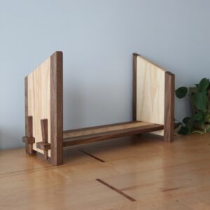 wooden bookshelf made of walnut & oak next to a plant