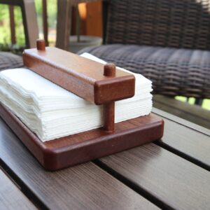 wooden napkin holder holding a bunch of napkin sitting on an outdoor table
